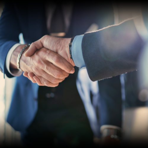 Two business people shaking hands, symbolizing the successful completion of the commercial auto insurance process in Montana.
