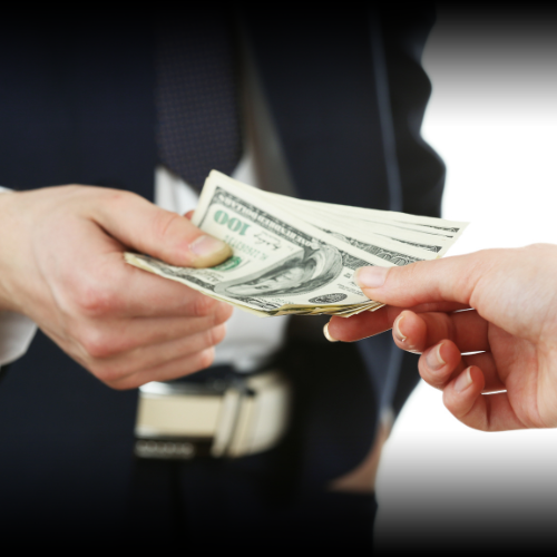 A man's torso is shown handing over a stack of money to an unseen recipient, symbolizing the financial compensation provided by an insurance company during a loss settlement.