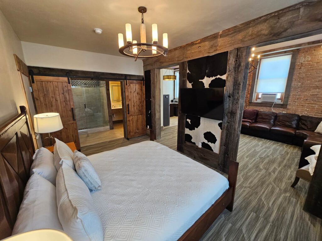 Superior Studio Suite at Eaglescape Suites & Event Center featuring an upscale, spacious layout with comfortable bedding, lounge seating, full kitchen amenities, and warm lighting in a downtown Miles City setting